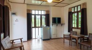 un soggiorno con sedie, un frigorifero e finestre di Khao Yai Country Hill Resort a Ban Na Sok