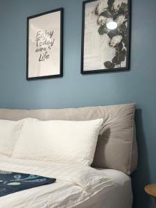 a bedroom with two pictures on the wall and a bed at Mira Apartments 2BR Apartment in Nadi Free Parking & WiFi in Nadi