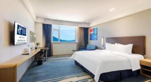 a hotel room with a large white bed and a desk at Holiday Inn Express Zhangye By IHG in Zhangye