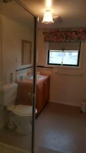 a bathroom with a toilet and a sink and a window at City townhouse walking distance to city in Launceston