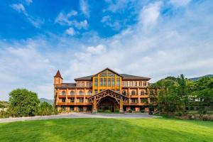 a large building with a green lawn in front of it at Beijng Chestnut Valley Hotel in Sanduhe