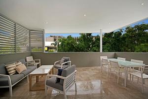 a living room filled with furniture and a patio at Jacaranda Noosa in Noosa Heads