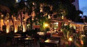 un ristorante con tavoli e sedie di fronte a un edificio di Royal Diamond Hotel a Phetchaburi