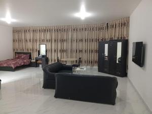 Big Studio In Abu Dhabi Corniche في أبوظبي: غرفة معيشة بها أريكة وسرير
