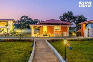 una casa con un sentiero di fronte di StayVista at Red Gable with Pool, Lawn a Dhamni