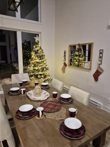 ein Esstisch mit einem Weihnachtsbaum im Hintergrund in der Unterkunft Spa Foosball Pool table Game Room - Le Kouzy in Sainte-Lucie-de-Doncaster