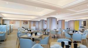 un ristorante con tavoli e sedie in una stanza di Vienna Hotel Nanning Xiangsi Lake University Town a Nanning