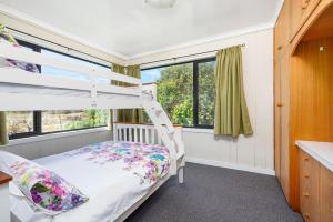 a bedroom with a bunk bed and a window at Farmhouse on the Cradle Coast Forth in Forth