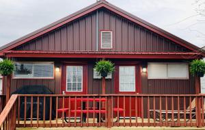 a red house with a deck and two chairs at Lakeland House in Langley +2 photos