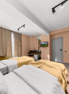 Un dormitorio con dos camas y un televisor en la pared. en Dastan Boutique Hotel Baku, en Baku