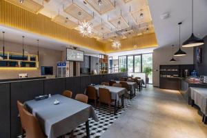 a dining room with tables and chairs in a restaurant at Xiamen Dongchen Hotel in Xiamen