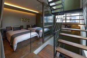 奈良市にあるCocon Nara Sanjyoのベッドルーム1室(ベッド2台付)、螺旋階段が備わります。