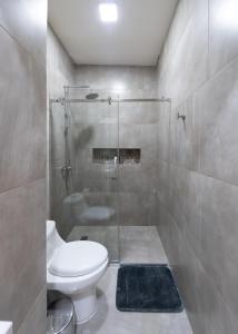a bathroom with a toilet and a glass shower at Lumina Suites in Cuenca