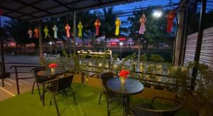 duas mesas e cadeiras com flores num pátio em P Bliss Hotel em Phayao