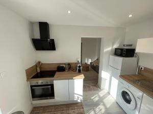 eine Küche mit Spüle und Waschmaschine in der Unterkunft Appartement Japandi proche Thermes Cocon Zen Contrexéville in Contrexéville