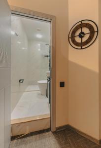 baño con aseo y reloj en la pared en Dastan Boutique Hotel Baku, en Baku 23 fotos más