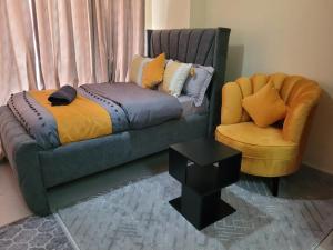 ein Schlafzimmer mit einer Couch, einem Sessel und einem Bett in der Unterkunft Grandmidtown Apartments in Nairobi