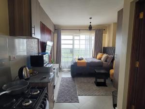 eine Küche und ein Wohnzimmer mit einer Couch und einem Bett in der Unterkunft Grandmidtown Apartments in Nairobi