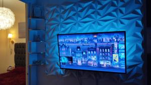 telewizor z płaskim ekranem wiszący na niebieskiej ścianie w obiekcie Exclusiva Casa con Alberca w mieście Bata