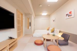 a room with a bed and a table and a tv at Tokyu Stay Meguro Yutenji in Tokyo