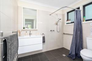 a white bathroom with a sink and a toilet at Farmhouse on the Cradle Coast Forth in Forth +33 photos