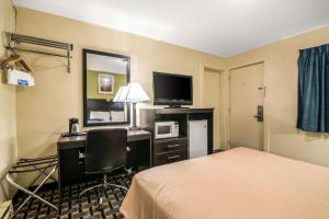 ein Hotelzimmer mit einem Bett und einem Schreibtisch mit einem Computer in der Unterkunft Rodeway Inn in Rutland
