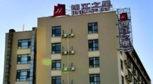 Un palazzo alto con un cartello sopra. di Jinjiang Inn JiNan Daminghu New Scenic Area Lishan Road a Jinan