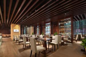 uma sala de jantar com mesas e cadeiras em um prédio em White Swan Hotel ChangSha em Changsha