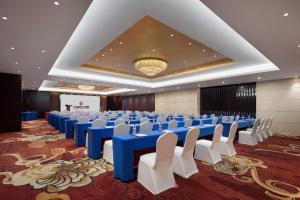 um grande salão de banquetes com mesas azuis e cadeiras brancas em White Swan Hotel ChangSha em Changsha mais 200 fotografias