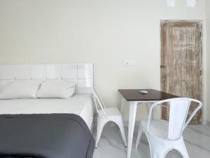 a bedroom with a bed and a table and a chair at The Lavana Kubu Be Long Sanur in Sanur