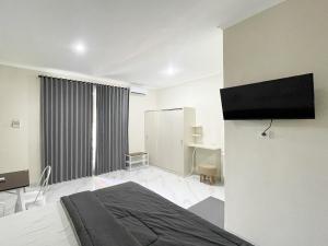 a bedroom with a bed and a television in it at The Lavana Kubu Be Long Sanur in Sanur