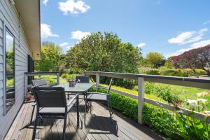 a patio with a table and chairs on a deck at Farmhouse on the Cradle Coast Forth in Forth