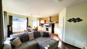 un soggiorno con divano e cucina di Ferienhaus Sanddorn am Hochzeitsberg a Breege