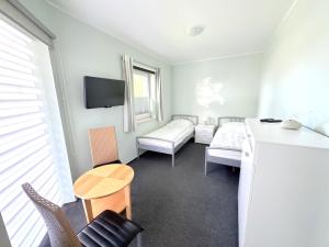 un piccolo soggiorno con tavolo e divano di Ferienhaus Sanddorn am Hochzeitsberg a Breege