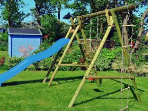 un'altalena di legno con uno scivolo blu di Ferienhaus Sanddorn am Hochzeitsberg a Breege