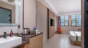 un bagno con lavandino e una camera da letto con un letto di GreenTree Inn JiangSu Changzhou Lijia Town Wujin Road Business Hotel a Changzhou