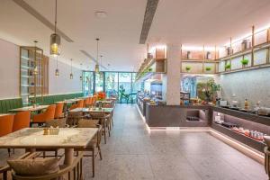 um restaurante com mesas e cadeiras em uma sala em Qingdao Galaxy Holiday Hotel em Qingdao