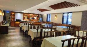 a dining room with tables and chairs in a restaurant at James Joyce Coffetel Xian Dayanta Metro Station Branch in Xi'an