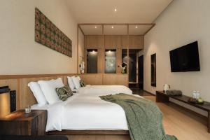 ein Schlafzimmer mit einem großen weißen Bett und einem Fernseher in der Unterkunft 西坡劳岭良室民宿 in Wukang