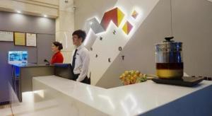 zwei Personen, die an einer Theke in einem Büro stehen in der Unterkunft Jingtu hotel zhanjiang dingsheng plaza store in Zhanjiang