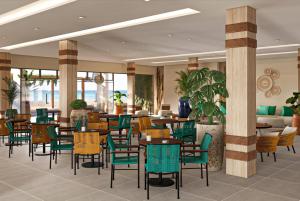 ein Restaurant mit Tischen und Stühlen in der Lobby in der Unterkunft Wyndham Natal Pitangui Praia in Extremóz