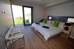a bedroom with a large bed with green pillows at Cliffhanger Estate in Keurboomstrand +35 photos