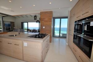 a large kitchen with a view of the ocean at Cliffhanger Estate in Keurboomstrand