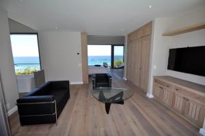 a living room with a couch and a glass table at Cliffhanger Estate in Keurboomstrand