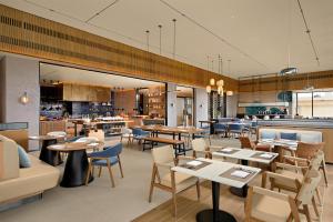 un ristorante con tavoli e sedie e una cucina di Hyatt Place Ha Long Bay, Bai Chay a Ha Long