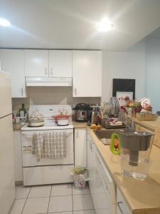 eine Küche mit weißen Schränken und einem weißen Herd mit Backofen in der Unterkunft charlotte in Montreal