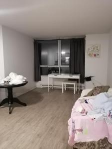 ein Wohnzimmer mit einem Bett und einem Tisch in der Unterkunft charlotte in Montreal