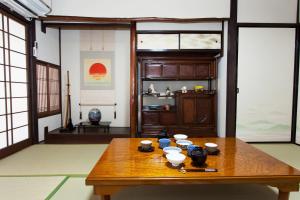 a room with a wooden table with bowls on it at Kujo Stays in Kyoto