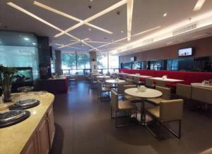 ein Speisesaal mit Tischen und Stühlen in einem Restaurant in der Unterkunft Zhangye Pinmu Hotel(Yuncheng Zhongyin Avenue Store) in Yuncheng