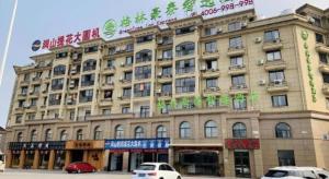 a large building with cars parked in front of it at GreenTree Inn Jiaxin Puyuan Kaixuan Road in Puyuan
